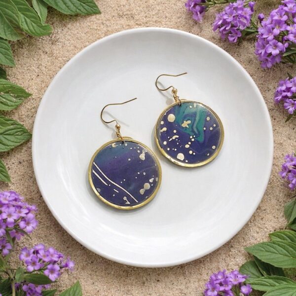 Charline Boucles d’oreilles rondes abstraites artisanales en papier calligraphié bleu et violet, montées sur un support en acier inoxydable doré. Bijoux faits main, légers et uniques.