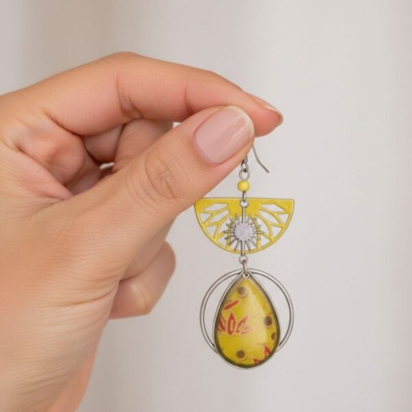 Appoline Boucles d'oreilles graphiques et dépareillées au jaune solaire, mêlant finesse ajourée et motifs floraux délicats.