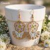 Daniela Boucles Blanches Papillons : boucles d'oreilles bohème en fleurs séchées et résine portées par une femme.