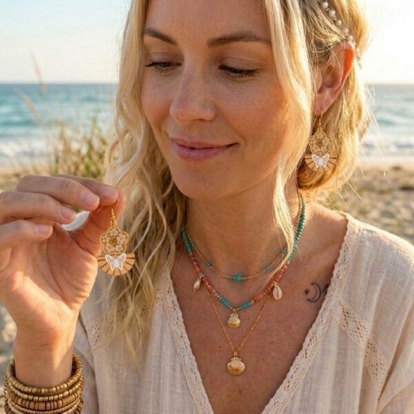 Détail des Daniela Boucles Blanches Papillons avec pétales de fleurs séchées, paillettes dorées et résine artisanale.