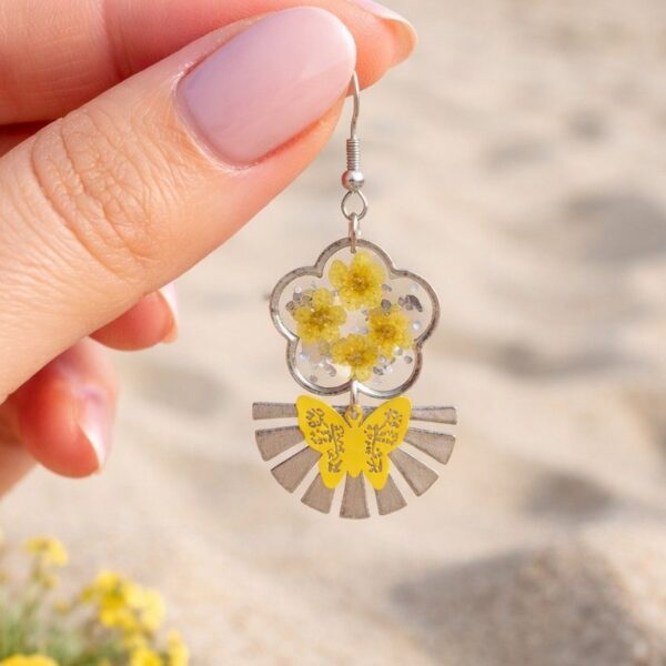 Zoom sur les pétales jaunes et paillettes argentées des Daniela Boucles Jaunes Papillons, éclat argenté et fleurs naturelles.