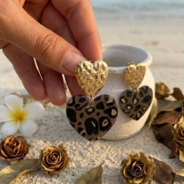 Gros plan sur la texture du papier calligraphié léopard et la résine brillante des boucles Eden.