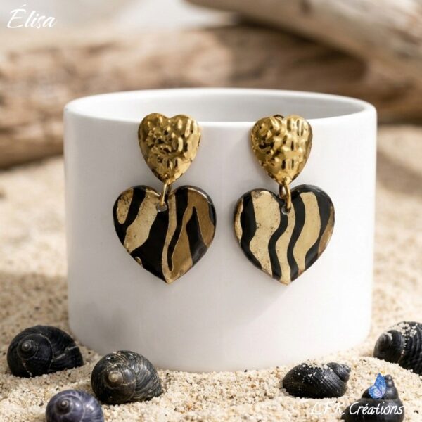 Élisa Boucles Cœurs Zébré motif zébré calligraphié à la main, finition résine brillante et poussoirs cœurs martelés en acier doré."
