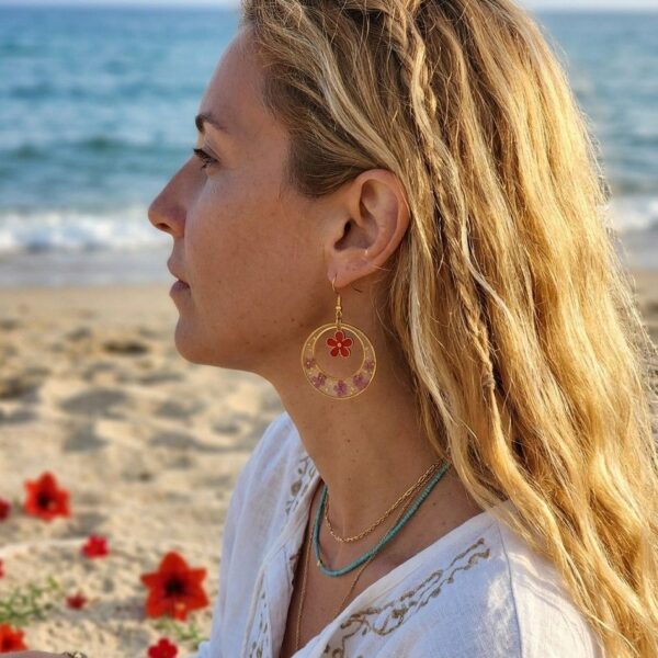 Bijou artisanal Mia porté, boucles d'oreilles créoles fleurs rouges et or.