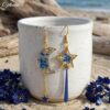Ophélie boucles dépareillées marine de L.F.K Créations, breloques lune et étoile en résine bleu marine et paillettes dorées."