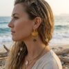 Portrait d'une femme portant les boucles d'oreilles asymétriques Samia, montrant la légèreté et le style sauvage élégant du modèle léopard et or.