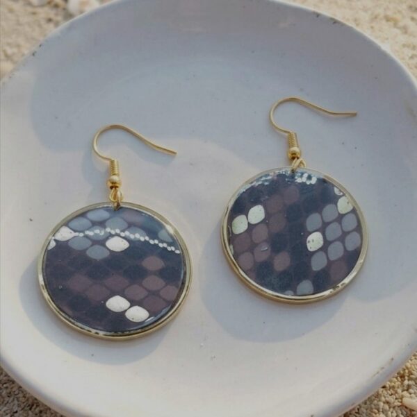 "Finition du dos des boucles Sarah : acier inoxydable doré poli et résine protectrice pour une qualité artisanale."