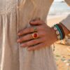 Bague dorée Sienna ajustable en acier inoxydable ornée d'une pierre naturelle Howlite rouge.