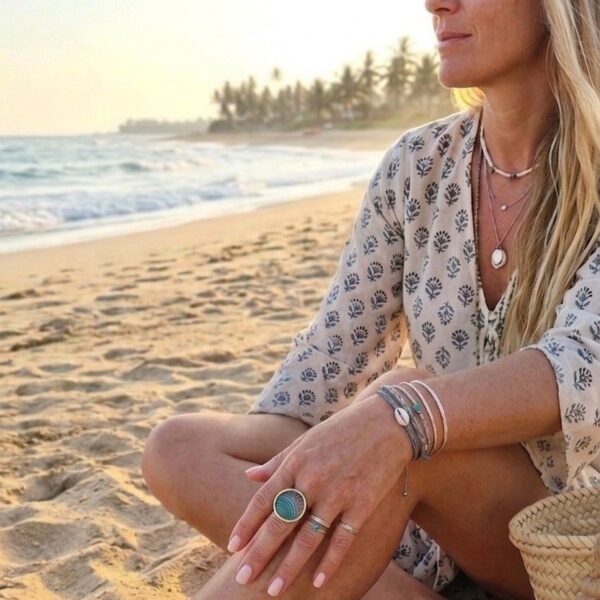 Main de femme portant la bague ajustable multicolore Sophia au style bohème chic et tendance.