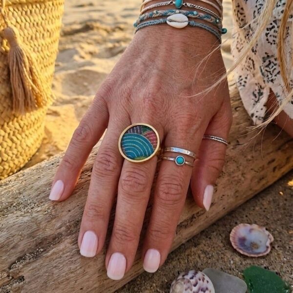 Main de femme portant la bague ajustable multicolore Sophia au style bohème chic et tendance.