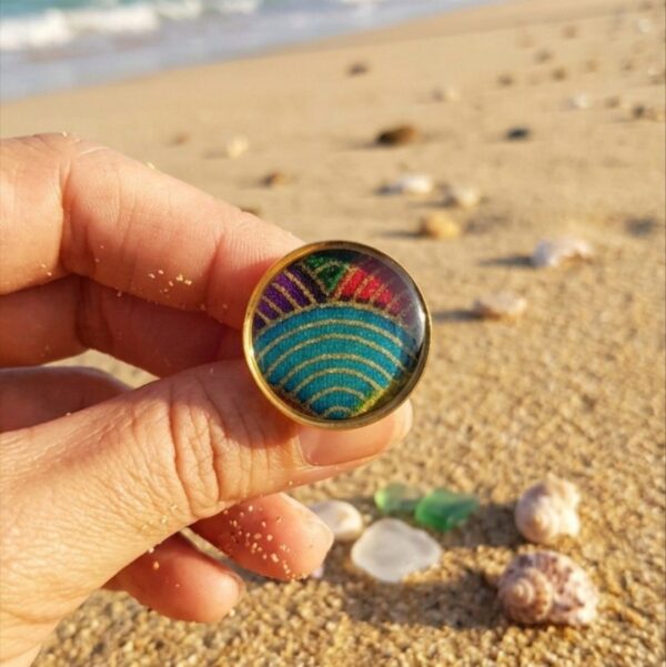 Gros plan sur le dôme en résine minérale et le tissu japonais multicolore d'une bague artisanale.