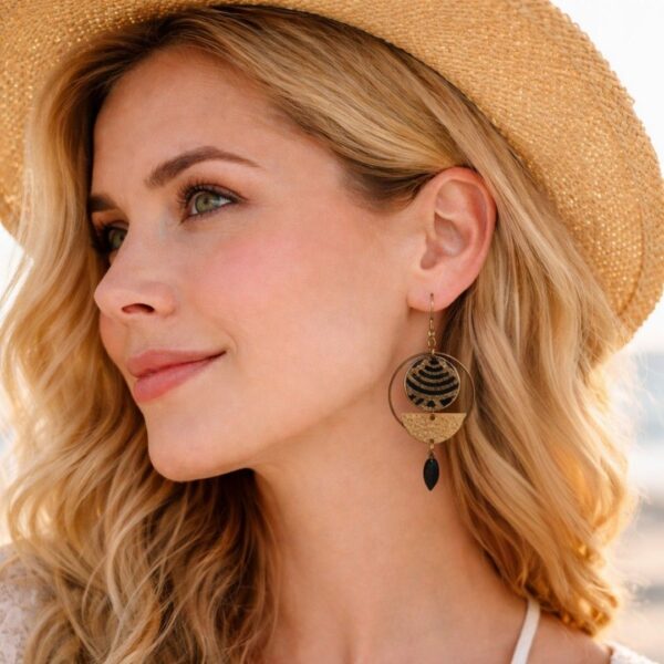 "Portrait rapproché des boucles d'oreilles Yuna portées, illustrant le mouvement des breloques dorées et l'élégance du tissu japonais noir sur le visage."