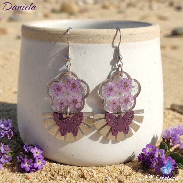 Daniela Boucles Fleurs Papillons : boucles d'oreilles solaires en fleurs violettes et résine cristalline.