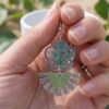 Zoom sur les pétales vertes et paillettes argentées des Daniela Boucles Papillons, éclat argenté et fleurs naturelles.