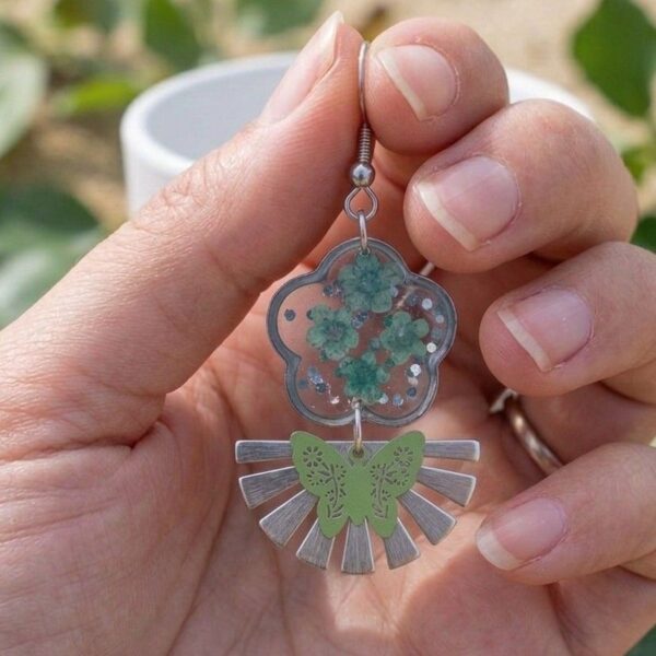 Zoom sur les pétales vertes et paillettes argentées des Daniela Boucles Papillons, éclat argenté et fleurs naturelles.