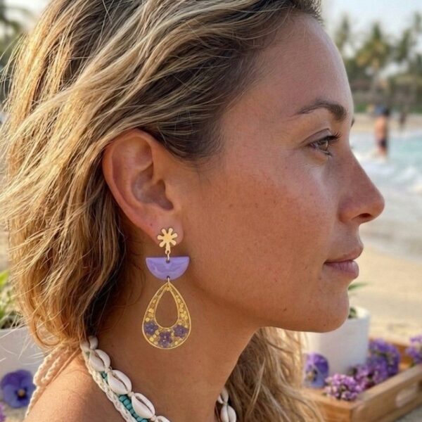 Femme portant les boucles d'oreilles légères Émilie en fleurs séchées et acier doré, bijou artisanal pour peaux sensibles.
