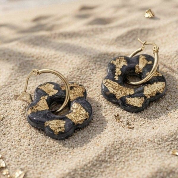 Créoles fleurs Capucine côté noir doré portée par une femme sur une plage