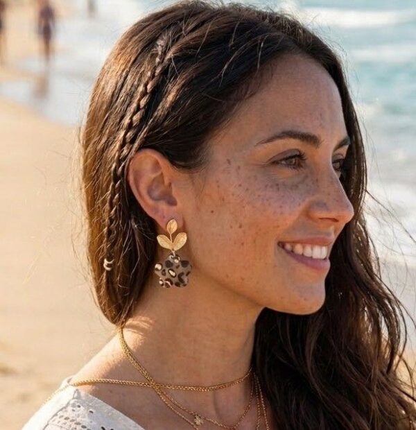 Boucles d'oreilles fleur léopard Clémence portée à l'oreille par une femme style bohème sur la plage