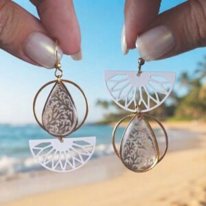 Gros plan sur les denise boucles asymétriques en papier calligraphié et acier inoxydable or