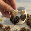 Boucles d'oreilles eden léopard tenues dans une main