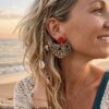 Boucle d'oreille demi-lune Naya motif léopard et puce rouge portée par une femme sur la plage au coucher du soleil - L.F.K Créations