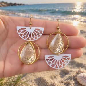 Gros plan sur les denise boucles asymétriques en papier calligraphié et acier inoxydable or